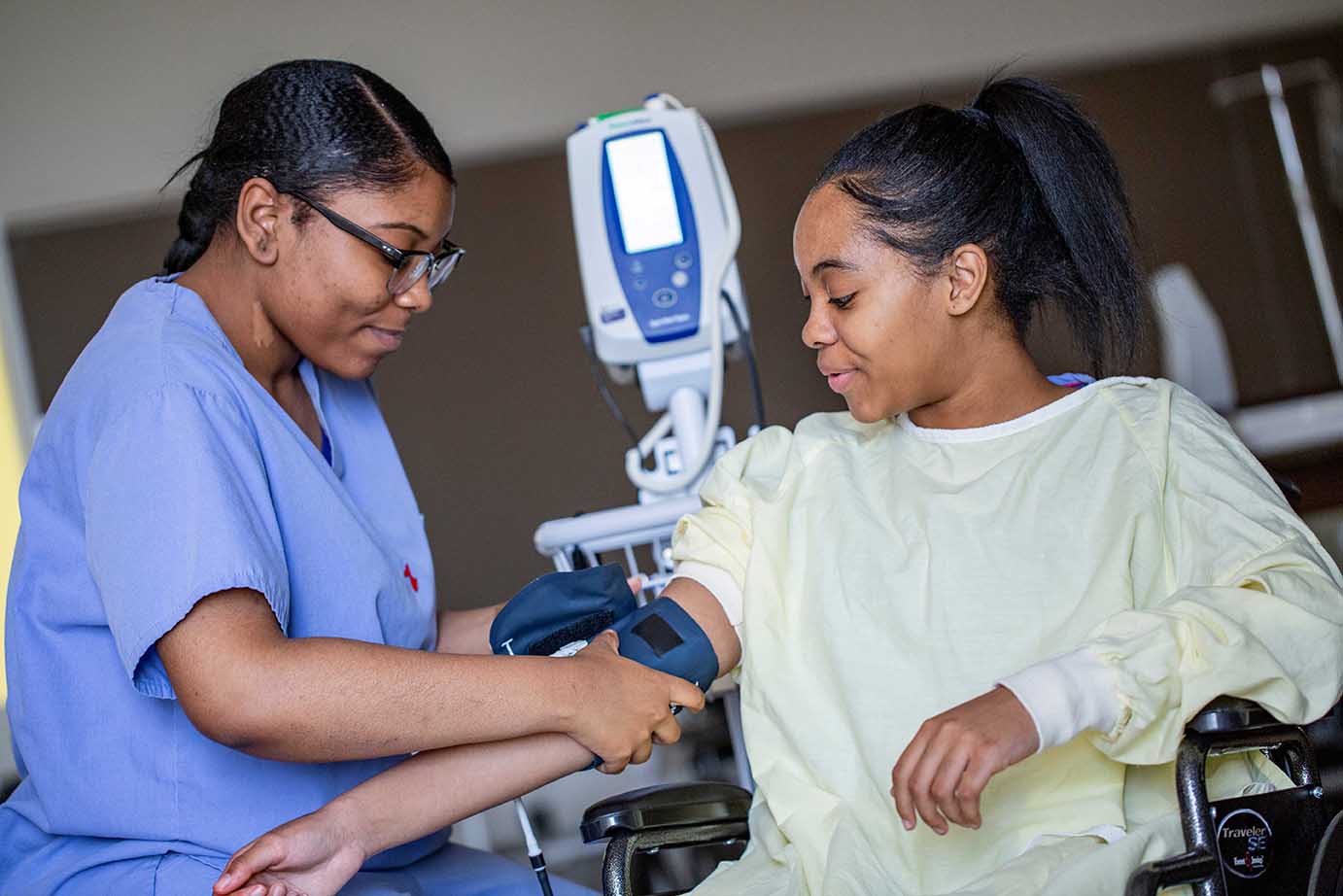  Student taking blood pressure of other student